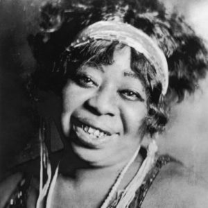 circa 1923: Portrait of American blues singer Ma Rainey (1886-1939), smiling, wearing a headband, beaded necklace, and a sequined dress. (Photo by Frank Driggs Collection/Getty Images)